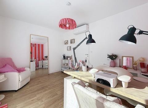 L'espace d'attente : fauteuil blanc, plaid rose et grand miroir doré